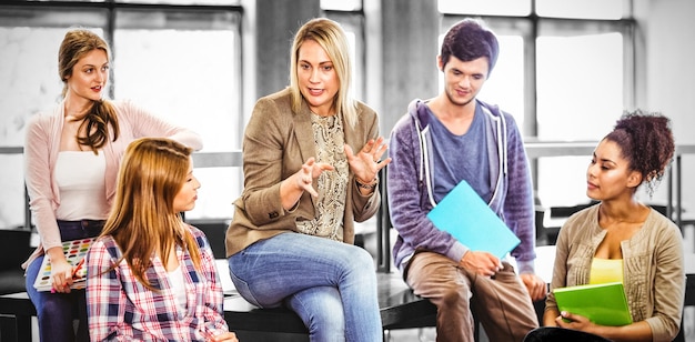 A group of high school students engaged in a lively class discussion, with the teacher facilitating and encouraging participation, representing the collaborative and communicative aspects of the Common Core ELA standards.