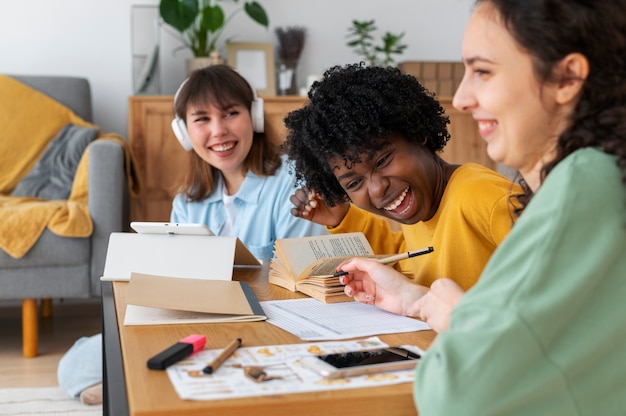 A diverse group of students is gathered around a table, intently listening to a financial advisor. The advisor is pointing to a presentation on a laptop screen, showcasing different loan forgiveness options and repayment plans. The setting is a brightly lit university common area.