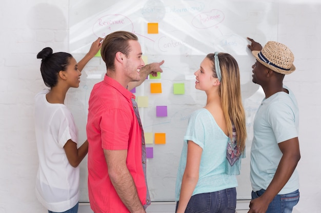 A diverse team of students brainstorming ideas in a collaborative workspace, using sticky notes and whiteboards to visualize their innovative solutions.