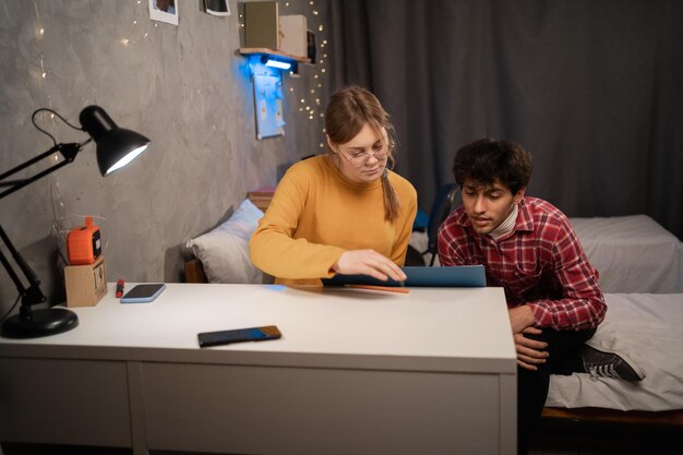A parent is sitting at a table with their child, reviewing math problems together in a brightly lit home setting, showcasing the personalized attention in homeschooling.