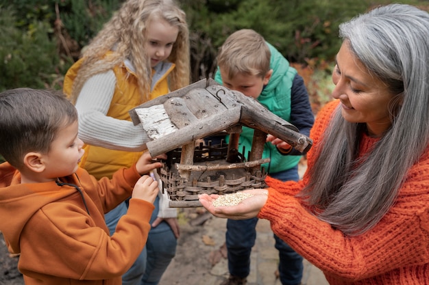 A group of homeschooled children are participating in a co-op science class, building a model volcano with the guidance of a parent volunteer, highlighting the social aspect of homeschooling.