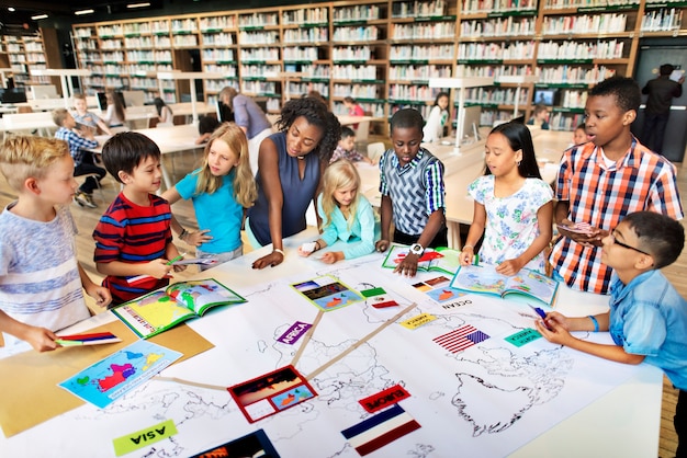 Students collaborating on a project in a high school classroom, surrounded by books and computers, showcasing teamwork and intellectual engagement.