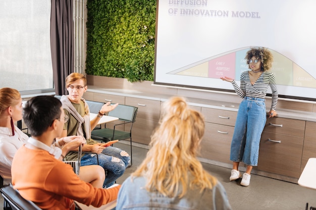 A student confidently delivering a presentation in a classroom setting, engaging with the audience and using visual aids effectively.