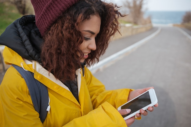 A person using a mobile app to track their expenses. The app displays categories like 