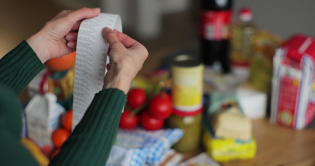 A person clipping coupons from newspaper circulars and organizing them in a binder with labeled sections, highlighting various grocery categories.