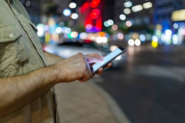 A medium shot capturing a person's hands using a transportation cost calculator app on a smartphone, with a background blurred cityscape and a focus on financial savings.