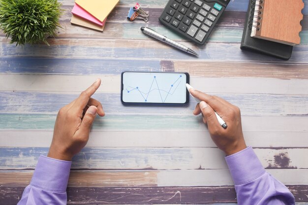 A person using a budgeting app on their smartphone, with different categories and spending amounts displayed on the screen.