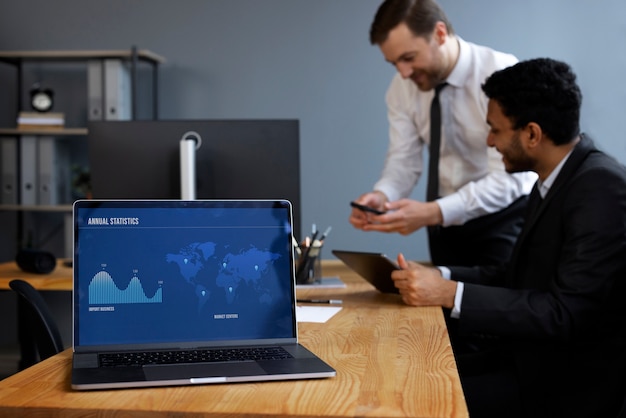 An investor setting up a DRIP account on a laptop, showing the steps and options involved. The scene is set in a modern office with stock charts in the background.