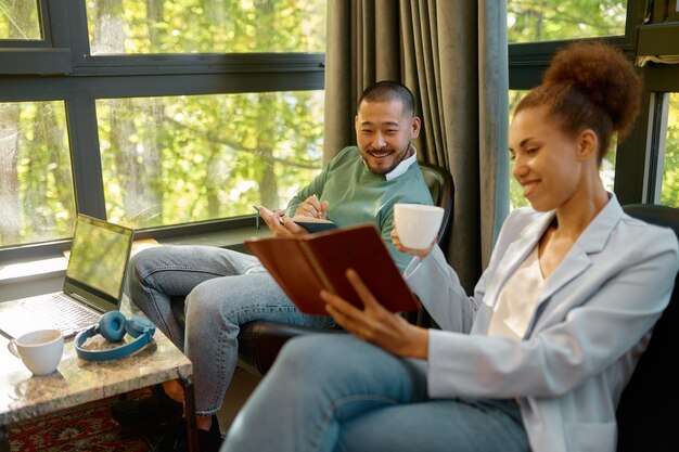 A close-up of a smiling counselor sitting across from an employee in a bright, inviting office setting. The counselor is holding a notepad and pen, listening attentively.