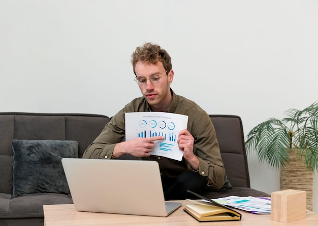 A person thoughtfully reviewing financial documents with accompanying graphs showing income, expenses, and investment portfolio allocation.