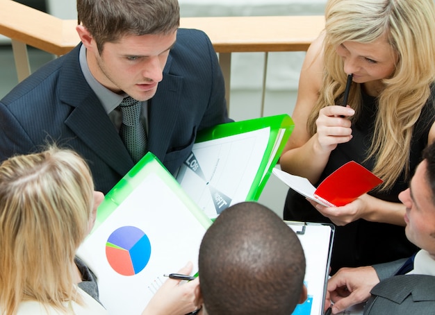 A close-up of a person reviewing complex financial documents related to employee benefits, with various charts and graphs visible on the screen. The lighting is professional, highlighting the detail and effort involved in managing benefits effectively.