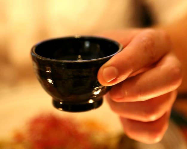 A close-up shot of a traditional Japanese teacup being prepared, subtly hinting at the cultural and personal themes found within the dramas. The focus is on the delicate details and the serene ambiance.