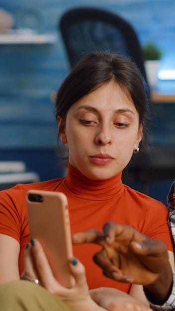 Close-up shot of a dorama producer reviewing social media comments and trends on a tablet, a coffee mug and script on the table, with a concerned and reflective expression, indicating the pressure of audience feedback.