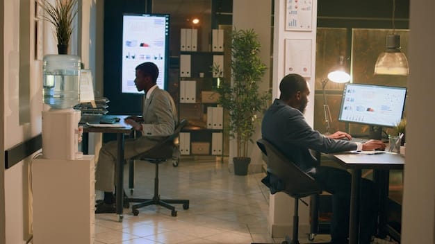 Digital editor sitting in modern office, working on multiple screens with data analytics dashboards and text editing software, surrounded by colleagues in a collaborative setting.