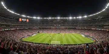 Packed MLS stadium at night with fans using digital tickets on smartphones